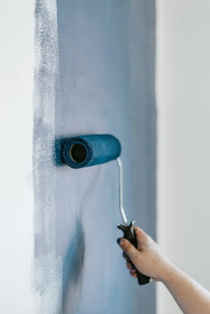 Pintor pintando una pared interior con rodillo