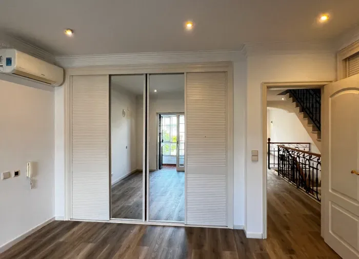 Dormitorio pintado de blanco con armario de espejo, listo para usar