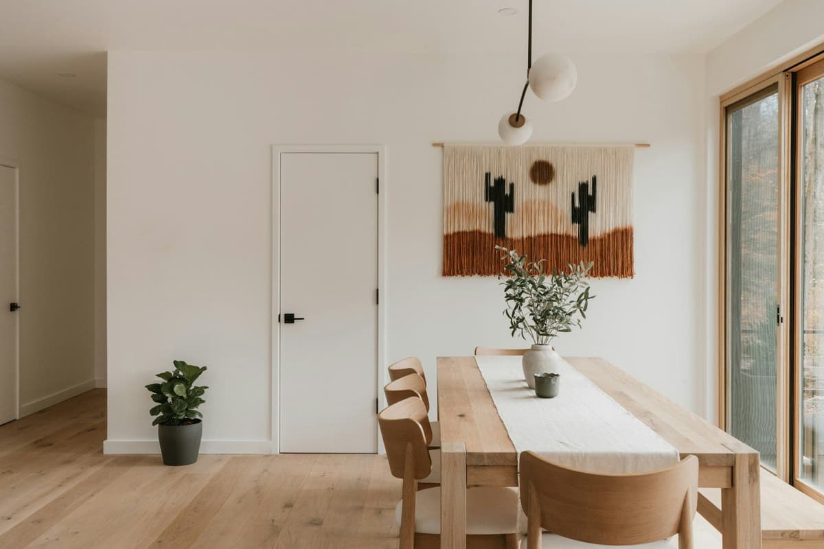 Modern dining room with desert-themed wall hanging.